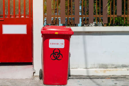 Biological Hazard Infecting Red Trash biohazard symbol sign, Used infectious masks and medical glove in the trash bin,infectious waste, prevented virus covid-19 by separating infected waste.の写真素材