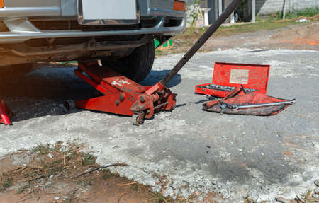 Extra safety measures are taken by using a hydraulic jack and jack stand to lift up a vehicle.の写真素材