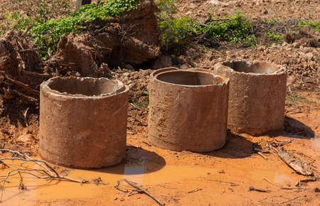 Old broken concrete cement pipe in grass,  Old concrete pipes, Cracked and deteriorated sewer pipes are left or placed on the ground.の写真素材