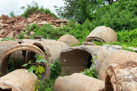 Old broken concrete cement pipe in grass,  Old concrete pipes, Cracked and deteriorated sewer pipes are left or placed on the ground.の写真素材