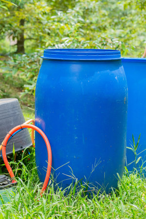 Blue plastic fertilizer tank in durian orchard, agricultural equipment for taking care of durian...