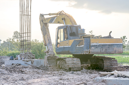 Big excavator on new construction site, in the background the blue sky and sun