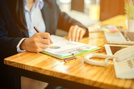 select focus hands of financial manager taking notes when working on report