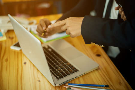 Business meeting time. working day in office. two businessmen at work. Notebook on wood table.の写真素材