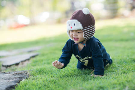 Asian cute little boy playing in the grass, child of a happy in the park