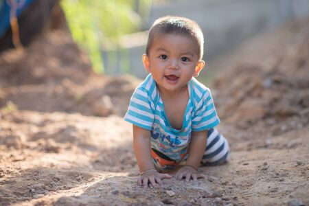 Portrait of cute small boy looking camera with happy and smiling on a nature background
