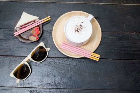 Coffee with sunglasses on wooden table backgroundの写真素材
