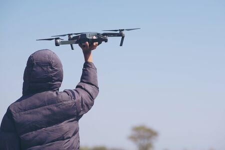 Cute boy holding drone at meadow, Child playing with drone outdoors at summer day