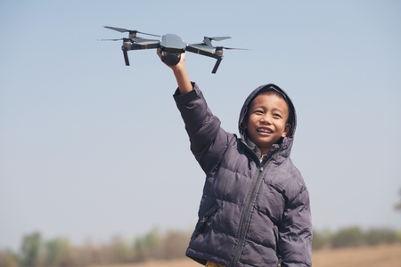 Happy little boy playing with the drone at the Wind turbines generating electricity.