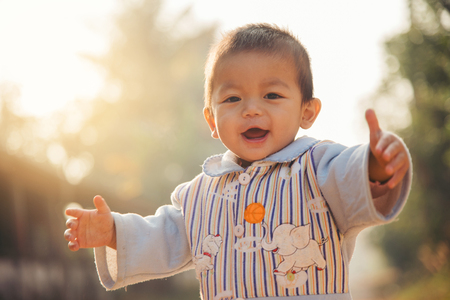 Happy little boy child is smiling enjoying adopted life. Portrait of young boy in nature,Concept of happy family or successful adoption or parenting.の写真素材