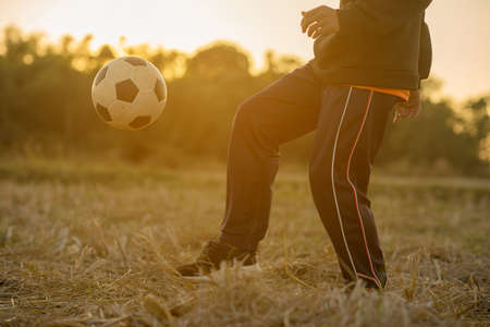 Boy playing soccer in the sunset