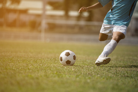 Close up Football player kick soccer in the stadiumの写真素材