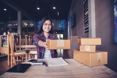 Young entrepreneur, teenager business owner work at home, box for delivery