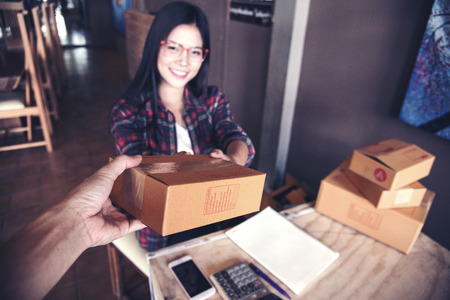 Young entrepreneur, teenager business owner work at home, box for delivery