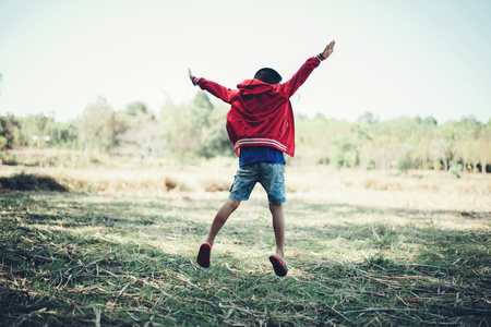 Happy boy child is jumping enjoying adopted life,Portrait of young boy in nature, park or outdoorsの写真素材