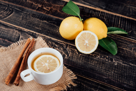 Glasses of  tea with lemon,Sliced lemons on a chopping boardの写真素材