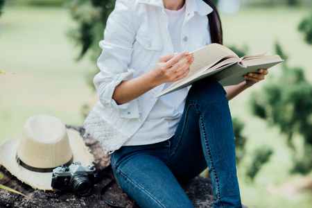 Beautiful girl in autumn forest reading a bookの写真素材