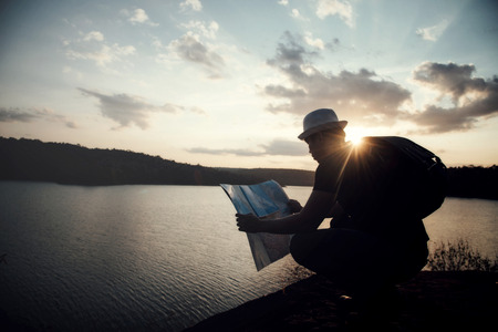 Tourist making photo of the nature, Man with map exploring wilderness on trekking adventure