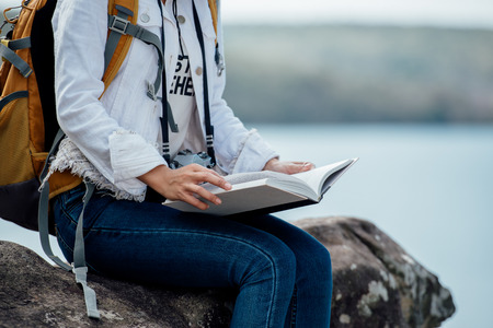 Beautiful woman reading book at mountain