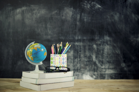Education or back to school Concept.world globe,books, glasses, pencils, over chalkboard background.の写真素材