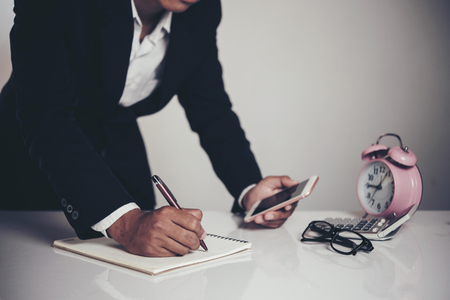 Businessman using smart phone in office background and copy spaceの写真素材