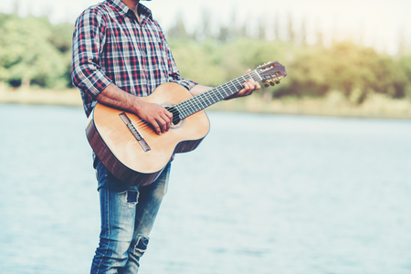 adult handsome musician playing acoustic guitarの写真素材