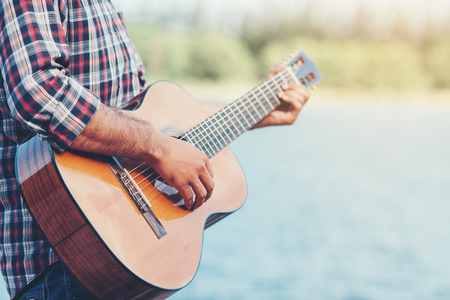 adult handsome musician playing acoustic guitarの写真素材