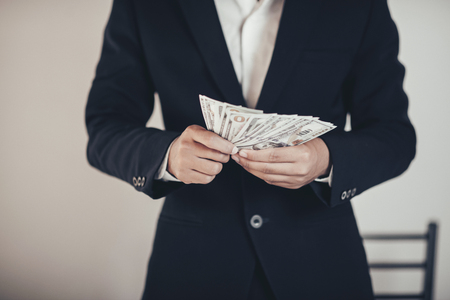 finances, economy and business concept. close up of Businessman with money on handの写真素材
