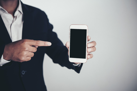 Businessman using smart phone on gray background and copy spaceの写真素材