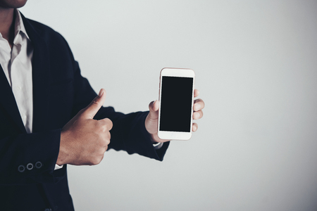 Businessman using smart phone on gray background and copy spaceの写真素材