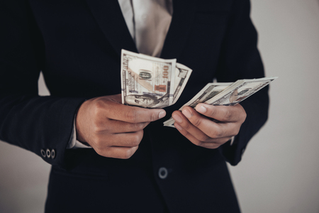 finances, economy and business concept. close up of Businessman with money on handの写真素材