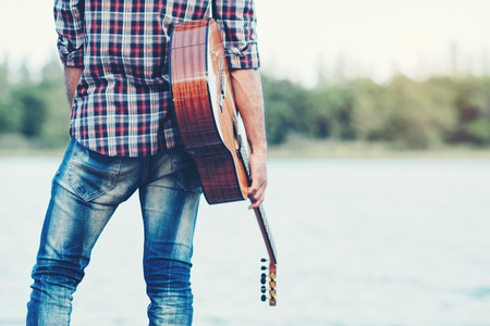 adult handsome musician playing acoustic guitarの写真素材