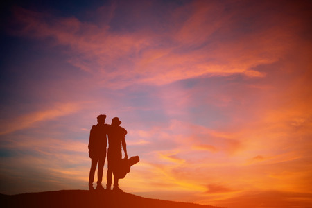 Silhouette of asia young two man with acoustic guitar, sunset backgroundの写真素材
