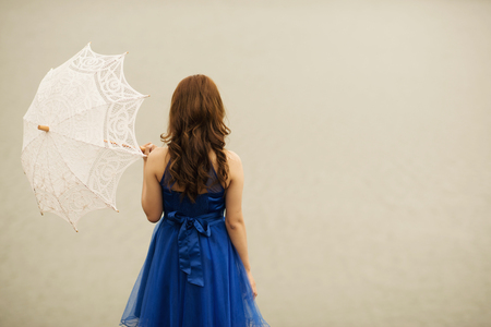beautiful woman with an umbrella on a background of natureの写真素材