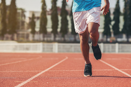 young fitness man runner athlete running at stadiumの写真素材