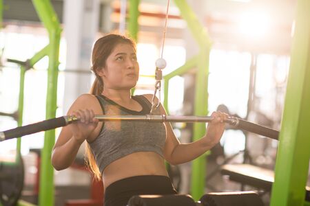 beautiful muscular fit woman exercising building muscles in th gym