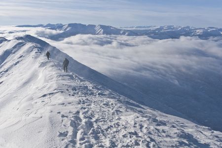 a blizzard on the mountain top with two climbersの写真素材