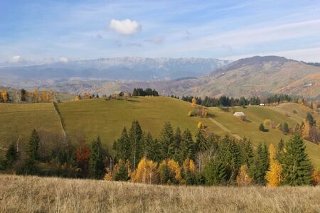 an autumn landscape with a mountain backgroundの写真素材