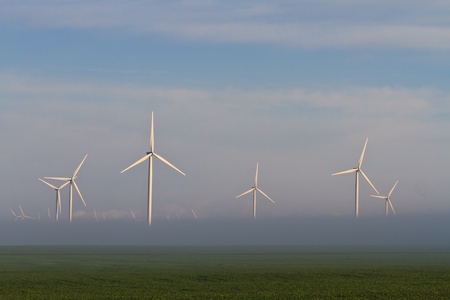 wind power turbines on a hill in fogの写真素材