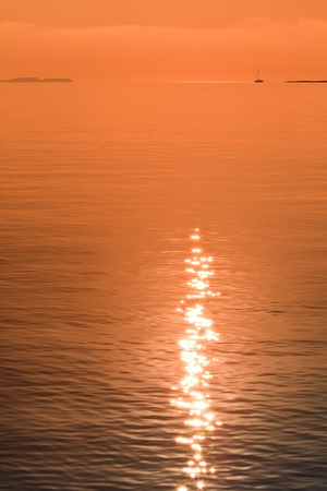 reflection of the sun at sunrise on seaの写真素材