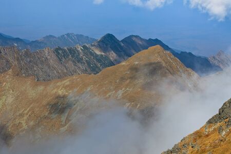 rows of mountains and a sky with clouds, Fagaras mountains, Romaniaの写真素材