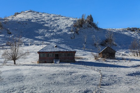 two rustic house on a snowy fieldの写真素材
