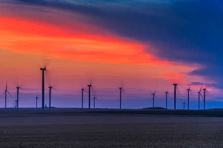 wind power turbines on a hill at sunsetの写真素材