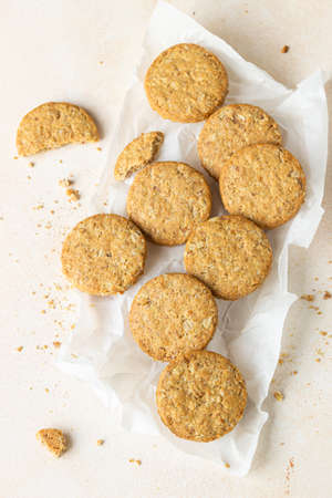 Healthy oatmeal or multigrain cookies with seeds and nuts on baking paper, light concrete background. Selective focus. Top view.の写真素材