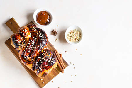 Babka or brioche bread with apricot jam and nuts. Homemade pastry for breakfast. Concrete background. Selective focus.の写真素材