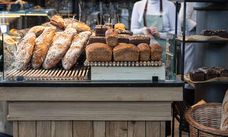 Variety of fresh baked artisan bread on a shelf in bakery shop. Gourmet breads for sale. Selective...