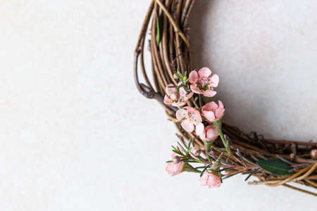 Detail of a decorative spring wreath made of twigs and flowers. DIY creativity. Close up. Selective focus.の写真素材