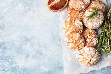 Homemade orange crinkle cookies with powdered sugar on baking paperの写真素材