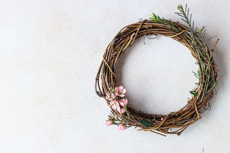 Decorative spring wreath made of twigs and flowers. DIY creativity. Selective focus.の写真素材