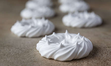 Empty meringue nests, light stone background. Concept for a tasty sweet dessert. Selective focus.の写真素材